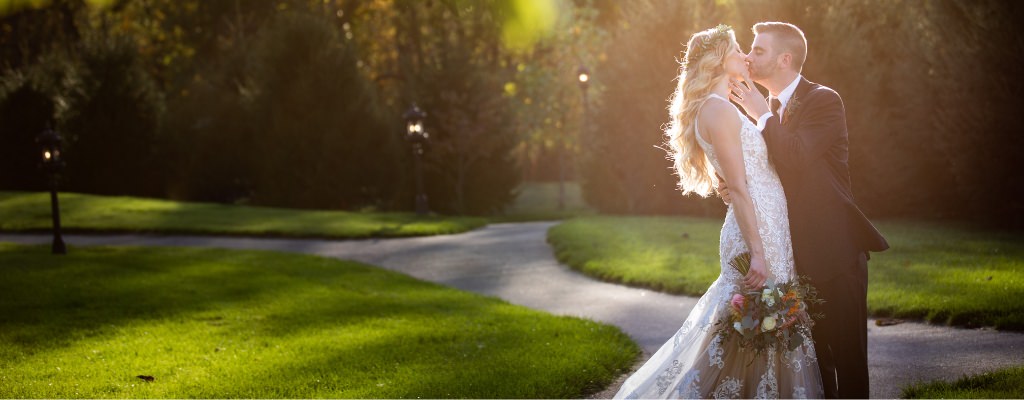 A bride and groom kissing in the bright sun