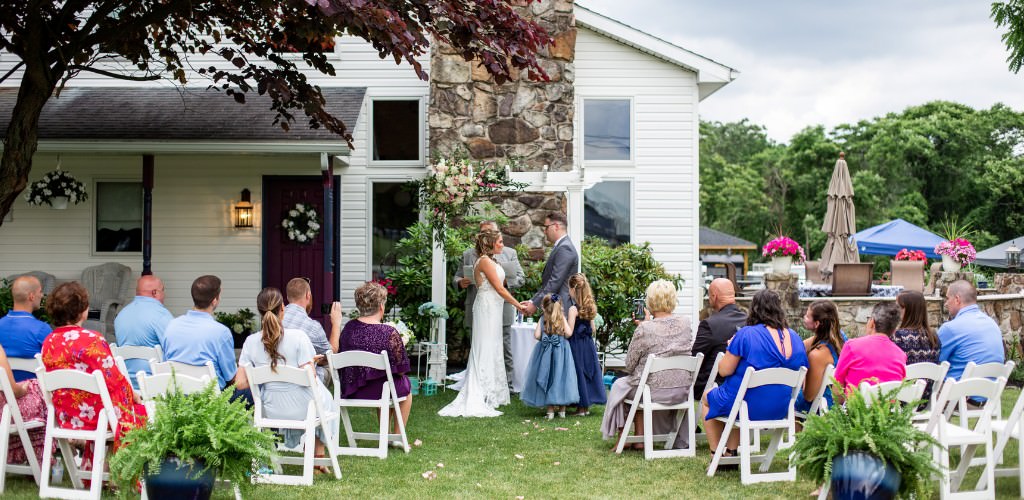 A bride and groom getting married at home in front of a small guest list consisting of a few family members and friends.