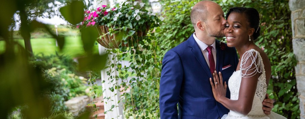 A groom kissing the bride on the cheek right after the wedding