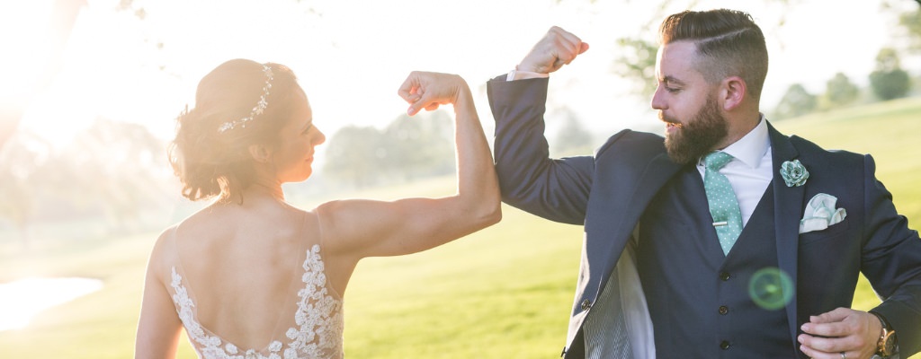 A bride and groom making muscles and showing off their fun personalities
