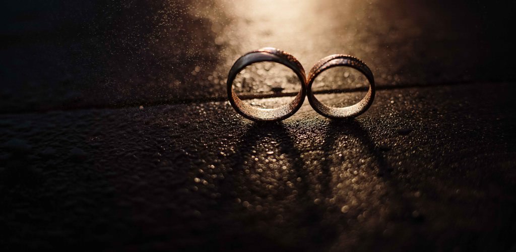 Two wedding rings with light coming from behind creating a cool shadow. This is for the blog post called how to save money on wedding rings