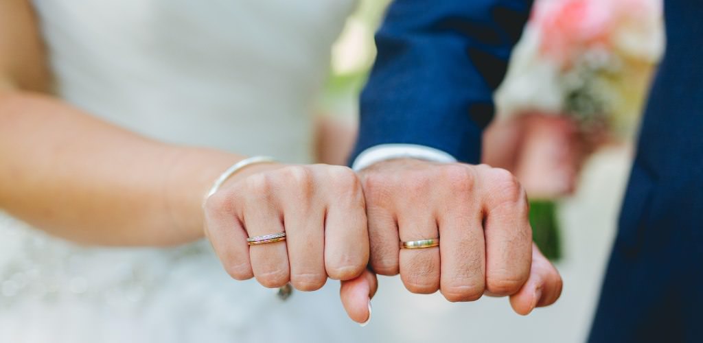 A bride and groom showing a close up of their new weddings rings