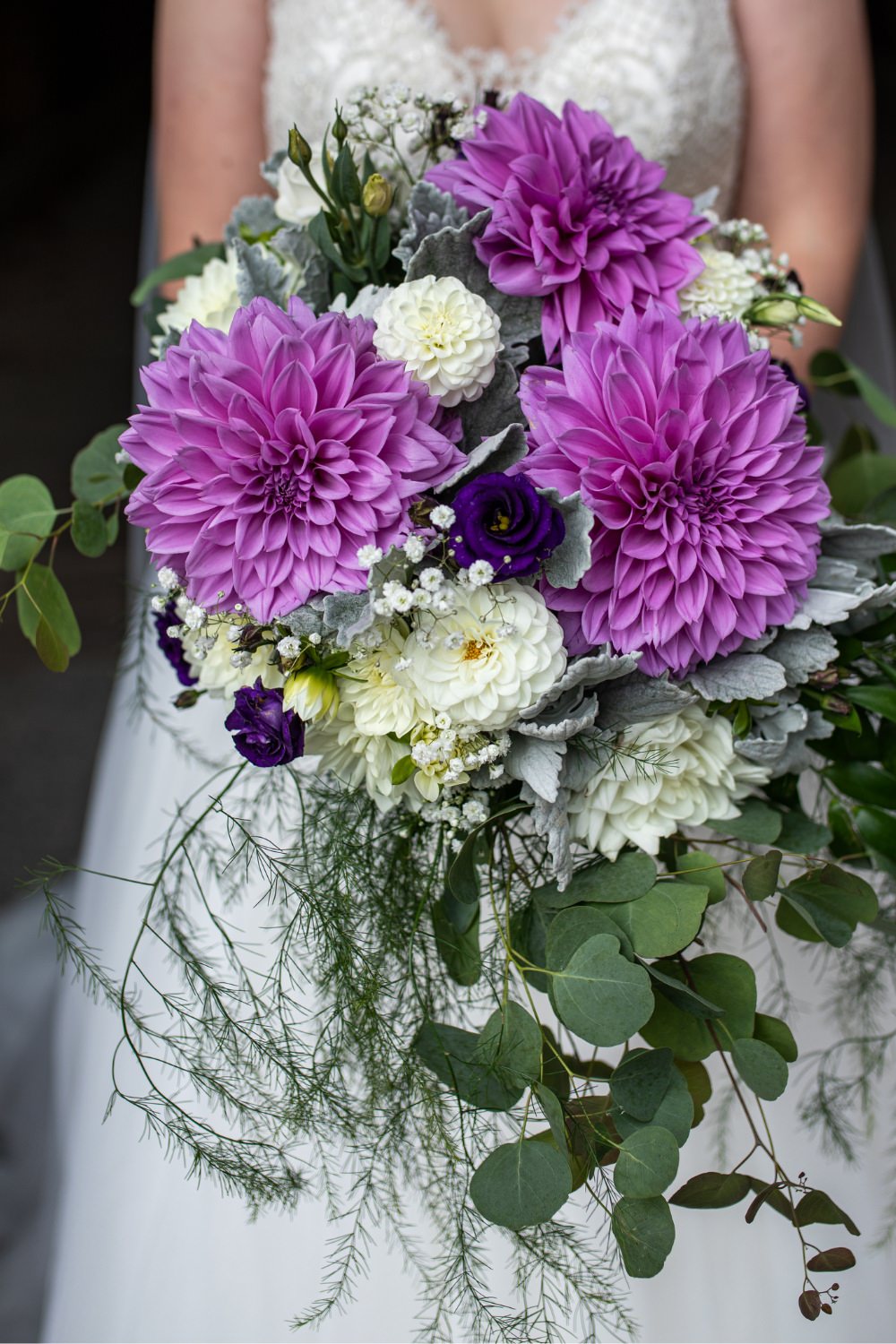 A big cascade wedding bouquet with purple flowers