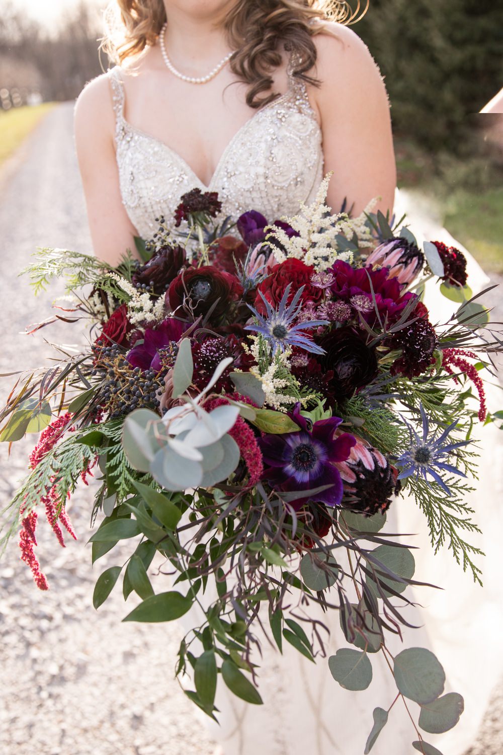 Dark and moody wedding bouquet with maroon and purple flowers