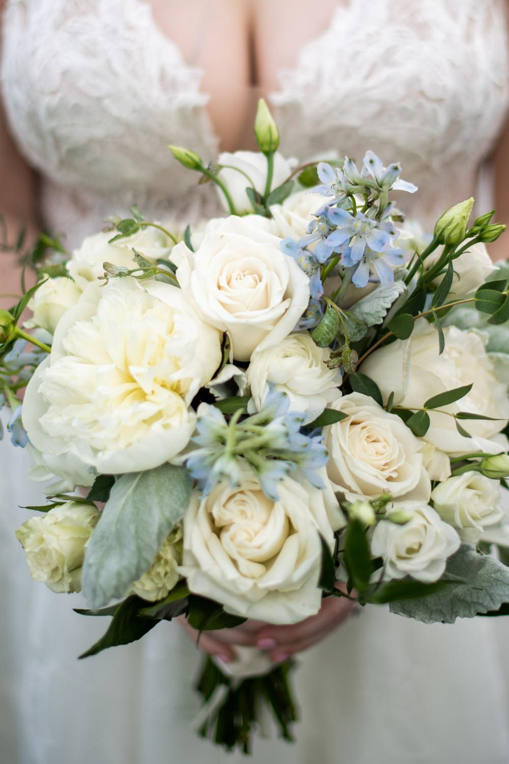 A close up photos a wedding bouquet with white roses