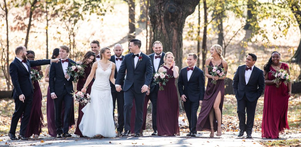 A bride and groom and their wedding party walking and laughing together