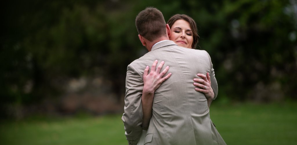 A bride hugging a groom after the wedding ceremony