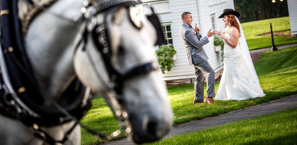 A bride and groom having fun together near a horse