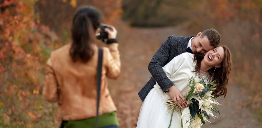 A wedding photographer taking photos of a couple