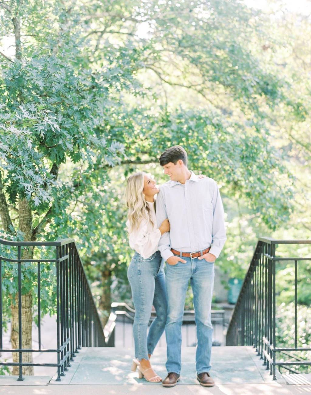 A stylish engagement photo with the couple in jeans. The girl is wearing high heels