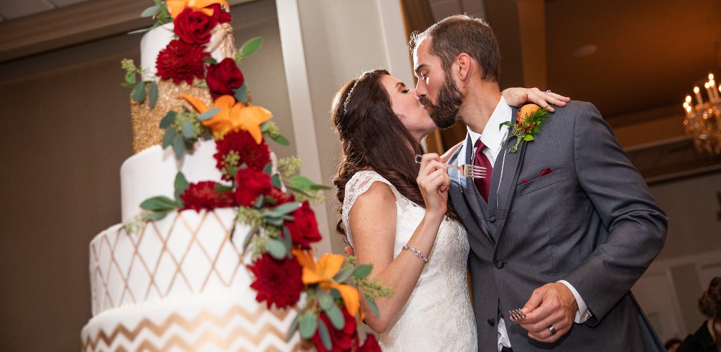 A bride and groom kissing after the cake cutting at their wedding