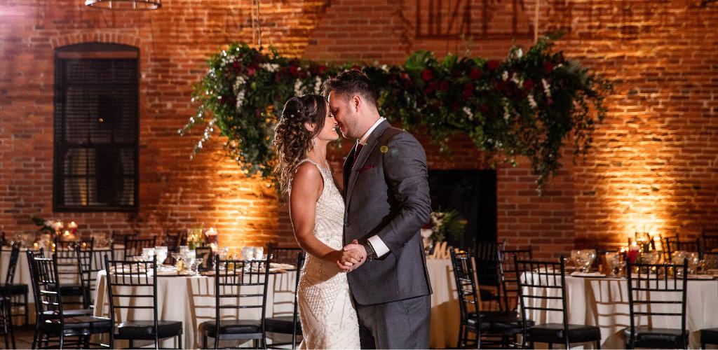 A bride and groom dancing closely in the reception room