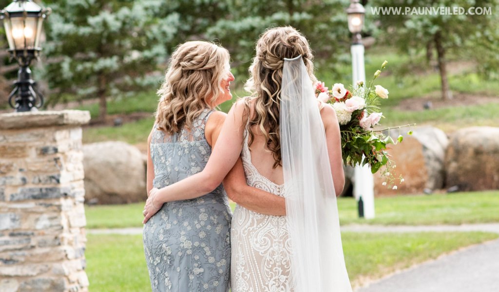 A bride and her mom walking down a path together
