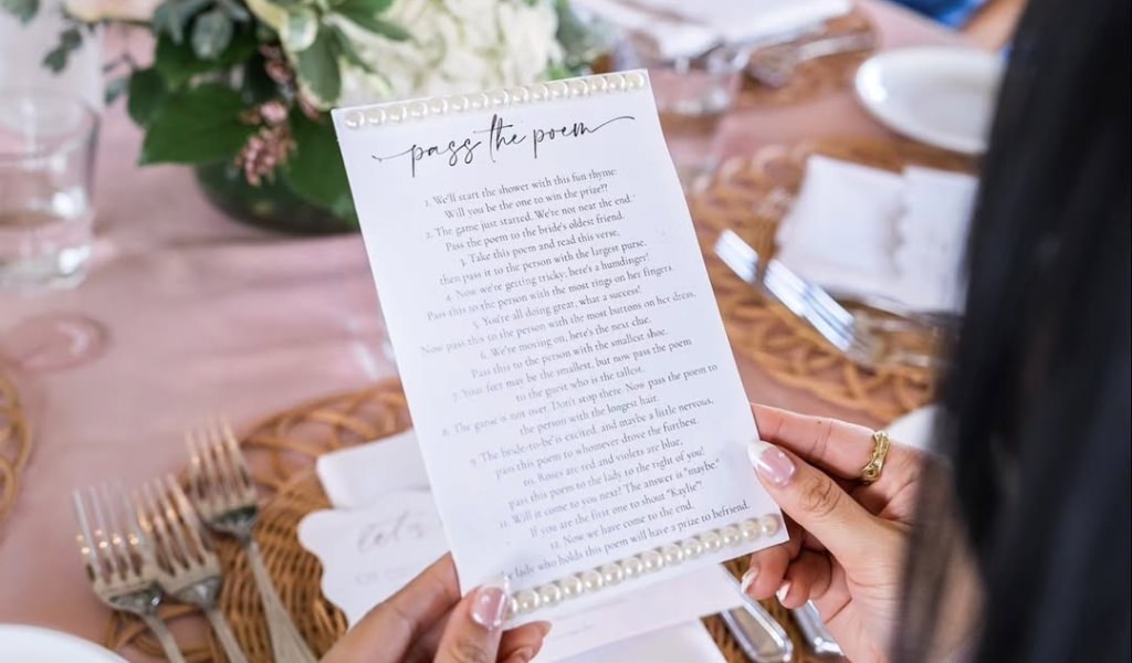 A pass the poem game card being held by someone playing the game at a bridal shower