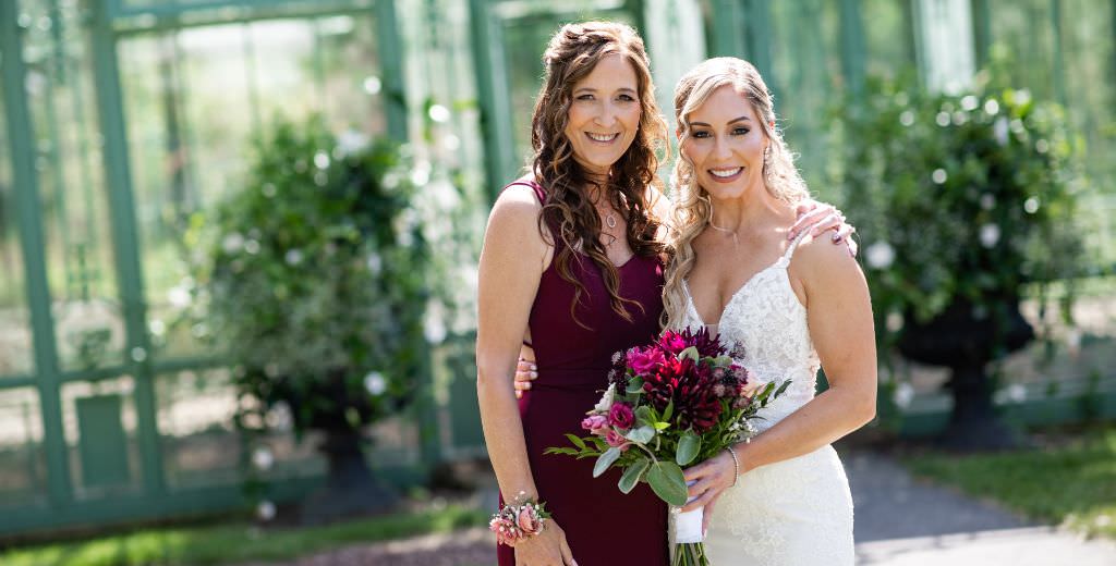 A bride posing with her mom on the wedding day