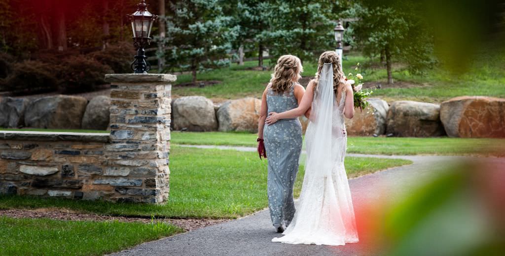 A bride and her mom taking a quiet walk together on the wedding day