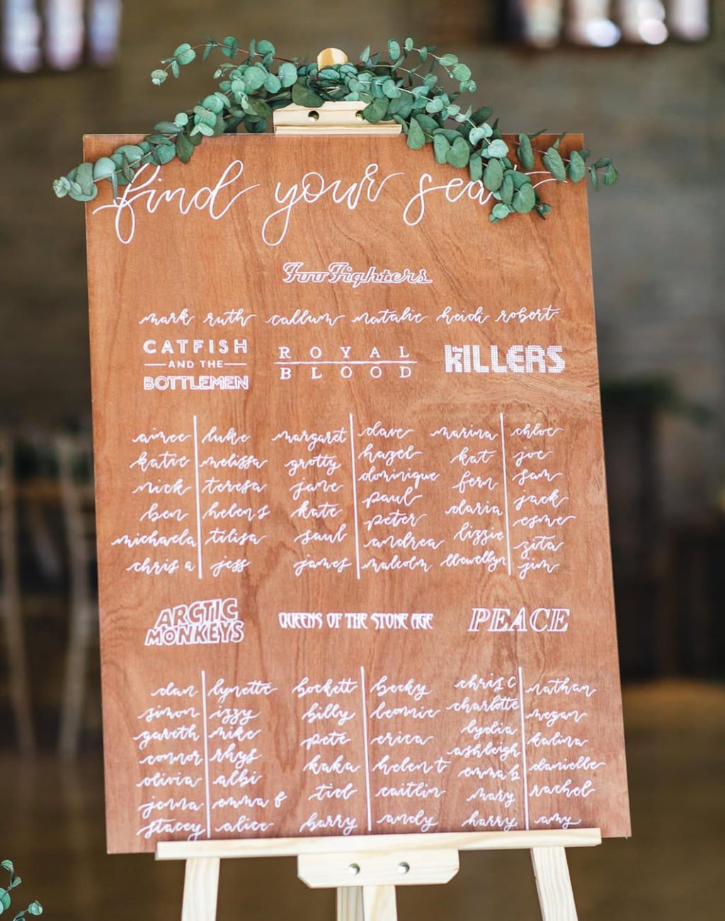 A cool wedding seating chart where each table is named after the couples favorite bands