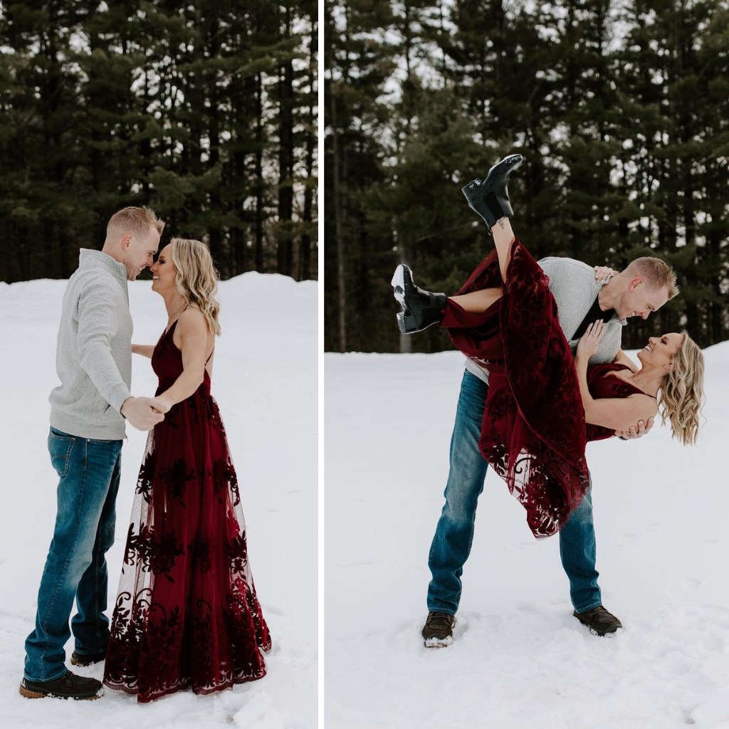 A playful couple posing for engagement photos in the snow. The woman is in a red lace dress