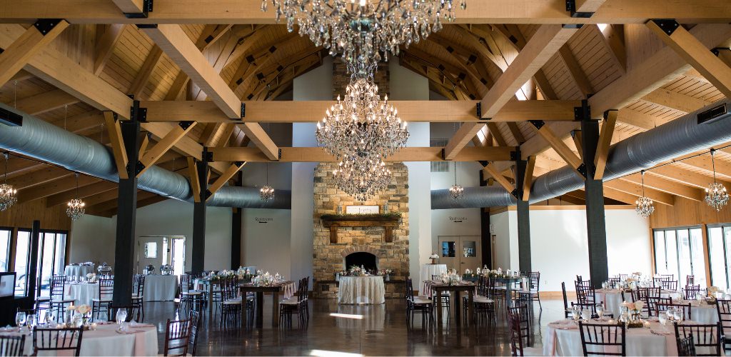 An indoor wedding reception set up at a beautiful venue with lots of windows