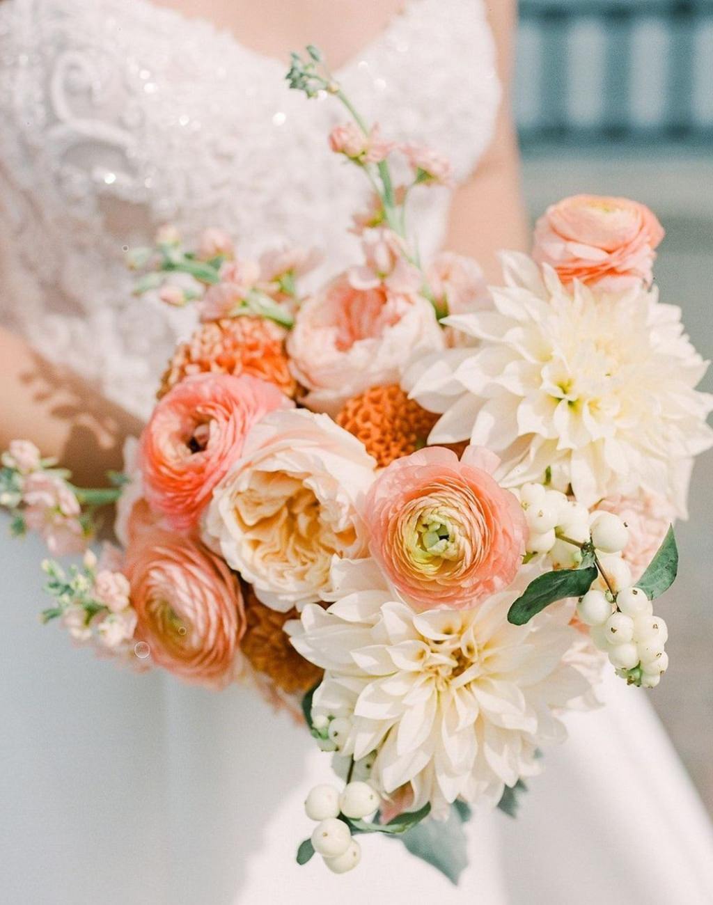 A wedding bouquet with orange and peach flowers