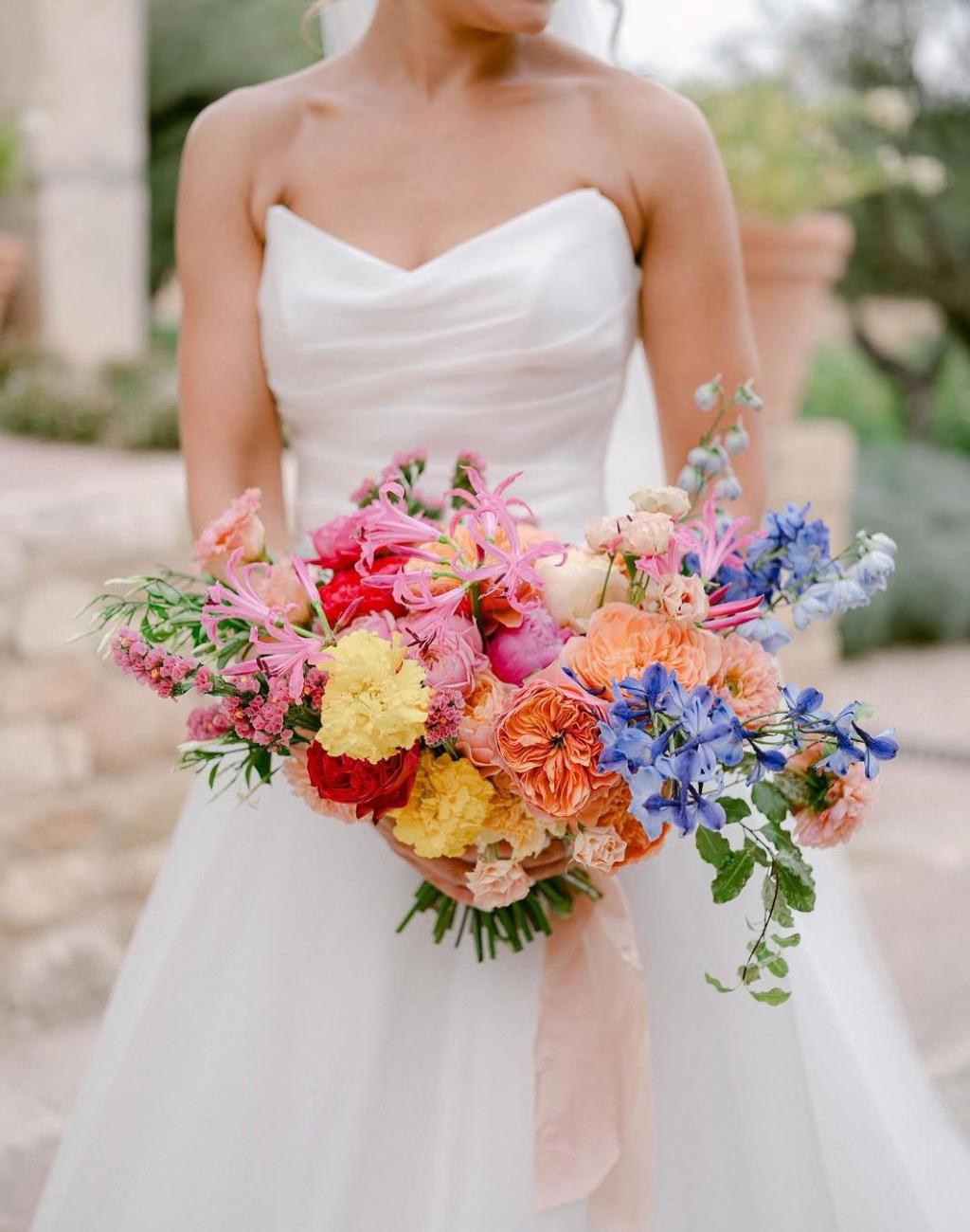 A rainbow colored wedding bouquet for a spring or summer wedding. This bouquet has flowers that are all colors of the rainbow