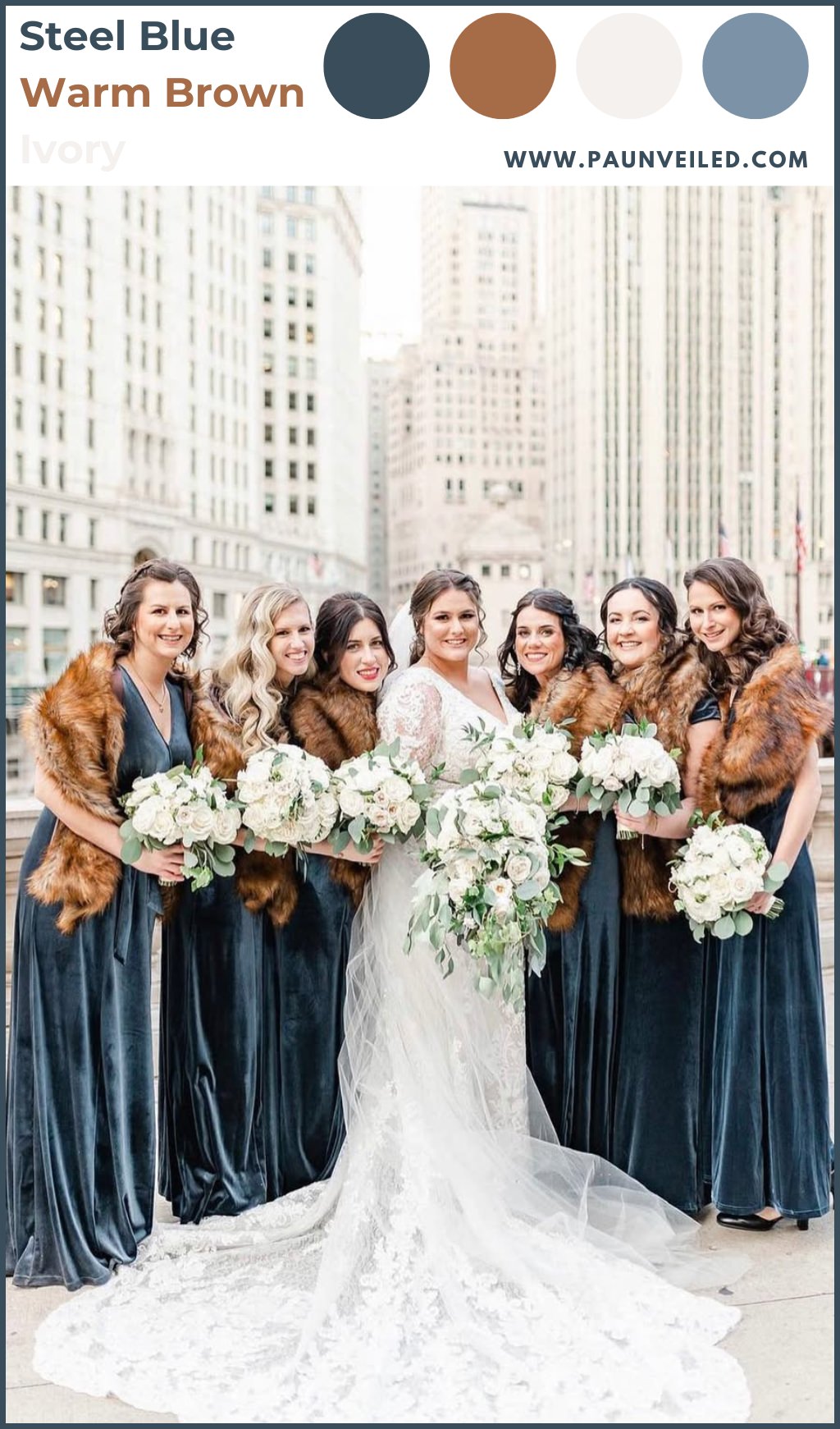A bride posing with bridesmaids in steel blue dresses and they are all wearing brown faux fur wraps to keep them warm.